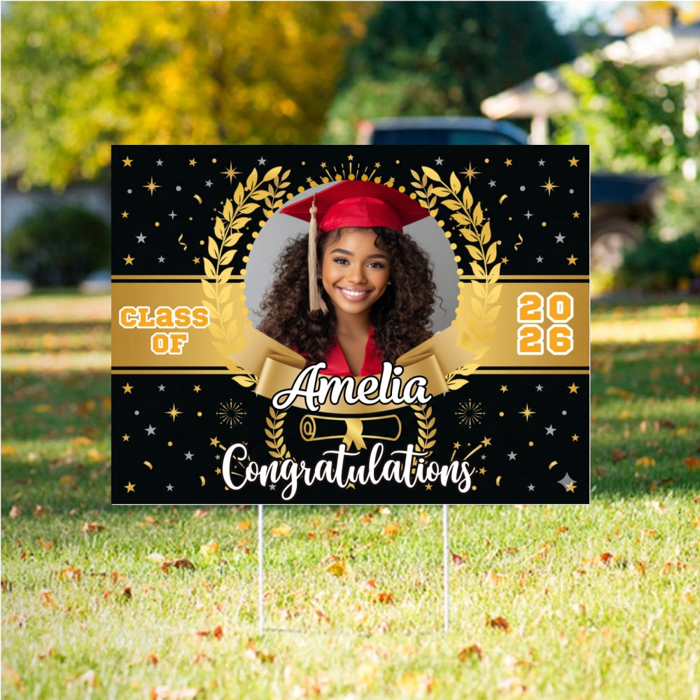 Graduation-themed decorative sign with a photo of a graduate, 'Class of 2026', and 'Amelia' on a grassy background.